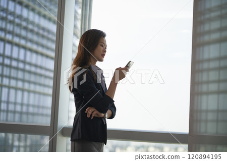 young asian businesswomen looking at mobile phone in modern office young asian businesswomen looking at mobile phone in modern office 120894195