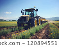 A farmer fertilizes plants with the help of a tractor and a sprayer. 120894551