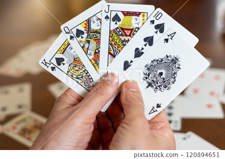 一個女人的手拿著一張黑桃撲克牌 一個女人的手拿著一張黑桃撲克牌 120894651