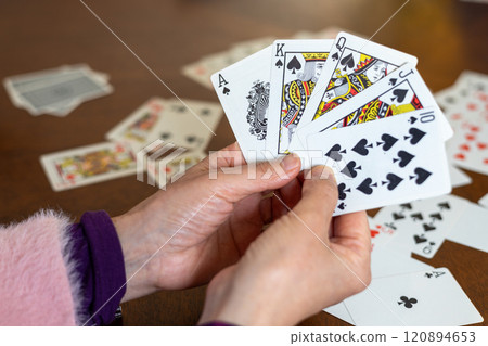 一個女人的手拿著一張黑桃撲克牌 一個女人的手拿著一張黑桃撲克牌 120894653