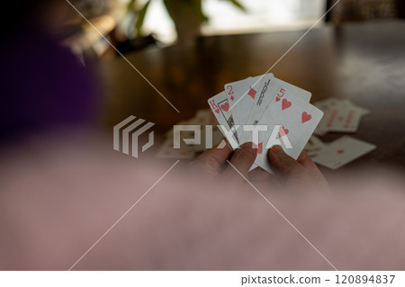 A woman holding a joker in her hand in Old Maid A woman holding a joker in her hand in Old Maid 120894837