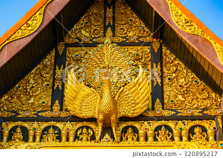Sculpture of golden Peacock at the facade of main hall in a buddhist temple. 120895217