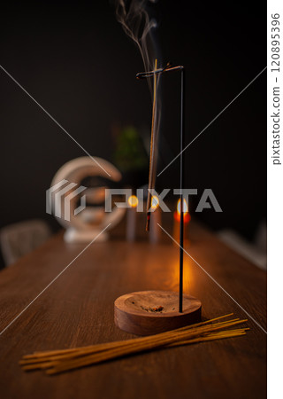 Incense sticks smoldering on table indoors, space for text Incense sticks smoldering on table indoors, space for text 120895396