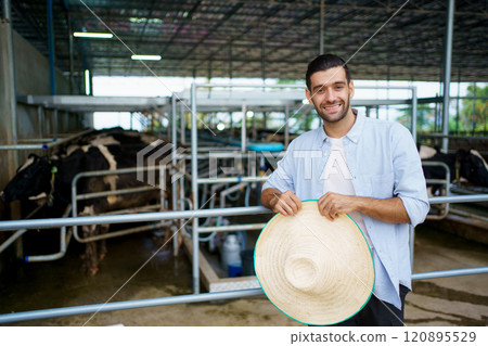 Portrait of cow milk agricultural farmer standing beside of the animal shelter in the farm. Livestock business owner portrait. 120895529