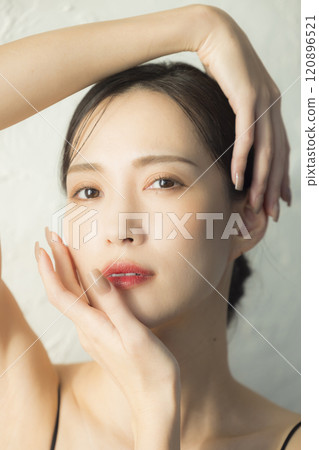 Young woman holding her hands to her face Young woman holding her hands to her face 120896521