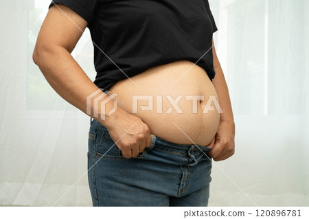 Overweight asian woman use hand to squeeze fat belly big size overweight and obesity. Overweight asian woman use hand to squeeze fat belly big size overweight and obesity. 120896781