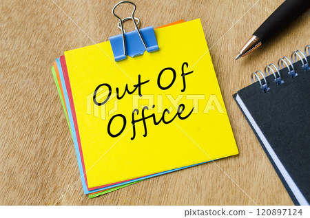 Top view of Out of Office text on yellow notepad. Holiday or vacation and away from work concept Top view of Out of Office text on yellow notepad. Holiday or vacation and away from work concept 120897124