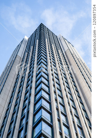 Multi-storey building with windows, view from below, clouds in the sky Multi-storey building with windows, view from below, clouds in the sky 120897354