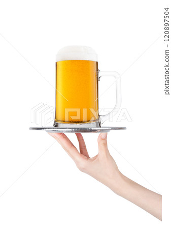 Hand holds tray with lager beer glass with bubbles 120897504