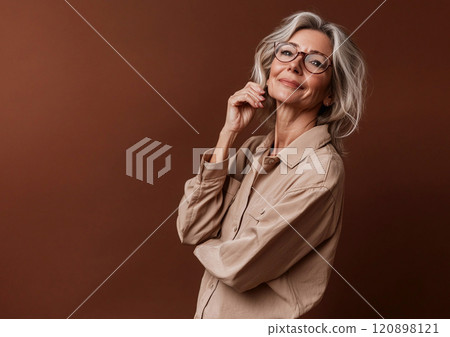 Beautiful mature woman with natural skin wearing beige shirt on brown studio background.Macro.AI Generative. 120898121
