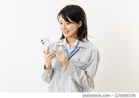 Female worker operating a smartphone 01 Female worker operating a smartphone 01 120898586