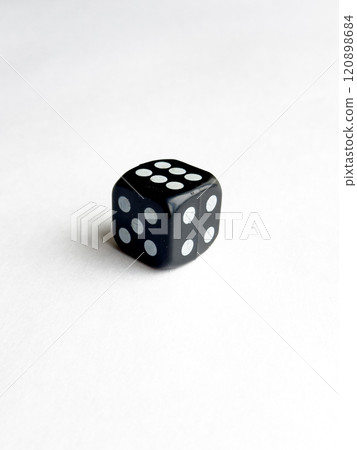 Black six sided dice on white surface with five dots Black six sided dice on white surface with five dots 120898684