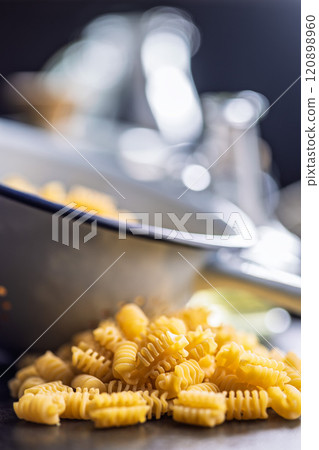 Uncooked italian pasta. Radiatori pasta on black table. 120898960