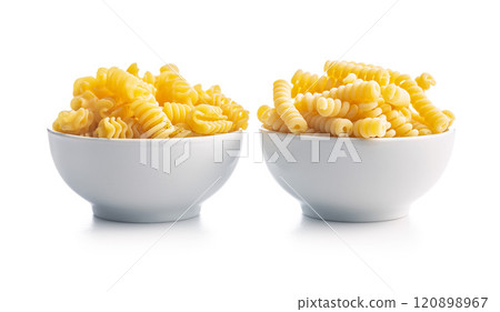 Uncooked italian pasta. Fusilli and radiatori pasta in bowl isolated on white background. Uncooked italian pasta. Fusilli and radiatori pasta in bowl isolated on white background. 120898967