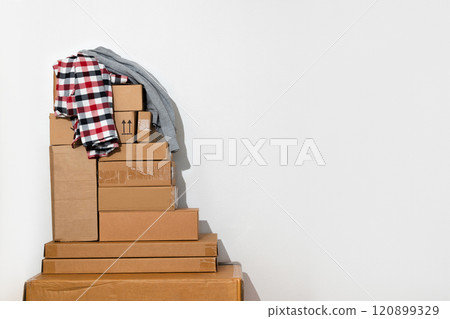 Pile of Cardboard Boxes with clothes in Minimalist Setting Pile of Cardboard Boxes with clothes in Minimalist Setting 120899329