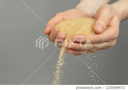 Hands pour crystalline cane brown unrefined healthy demerara sugar Hands pour crystalline cane brown unrefined healthy demerara sugar 120899472