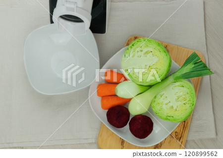 Cabbage, carrot, beet and onion near vegetable cutter on kitchen table. Chopped vegetables. Homemade healthy food. Health line. 120899562