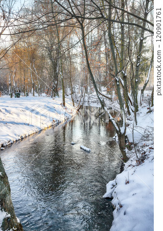 Breathtaking landscape in city park with snowy trees and beautiful reflection in frozen river. 120901761
