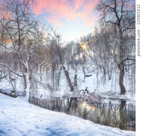 Outstanding landscape in city park with snowy trees and beautiful reflection in frozen river. 120901812