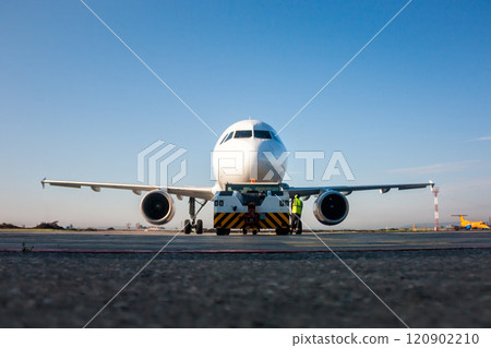Tow truck is pushing back the passenger airplane Tow truck is pushing back the passenger airplane 120902210