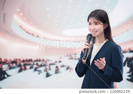 一位身穿西裝的年輕女子在大廳主持並發表演講 120902239