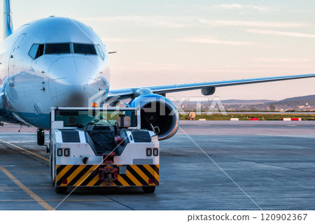 Tow tractor is pushing the passenger airplane Tow tractor is pushing the passenger airplane 120902367