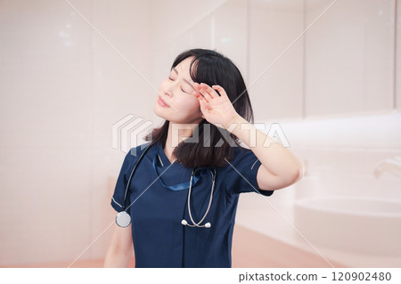 A female medical worker getting dressed in the restroom 120902480