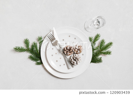 Festive table setting for Christmas dinner with silver cutlery on white background. View from above. Festive table setting for Christmas dinner with silver cutlery on white background. View from above. 120903439