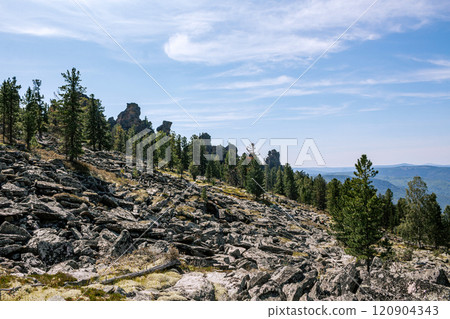 Natural landscape. Accumulations of sharp-angled stone blocks and ridge of rocks in a coniferous forest at background Natural landscape. Accumulations of sharp-angled stone blocks and ridge of rocks in a coniferous forest at background 120904343