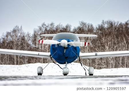 Front view of the shrouded small sports airplane at the winter airfield 120905597