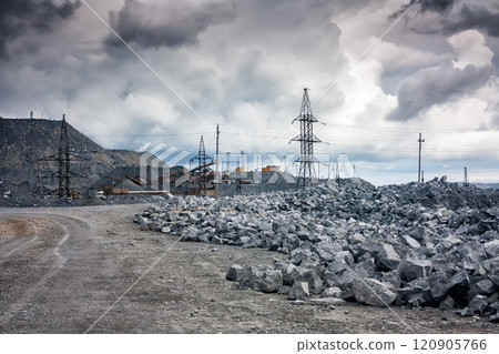 Stone dumps, power lines and crushing machines in a quarry in cloudy weather Stone dumps, power lines and crushing machines in a quarry in cloudy weather 120905766