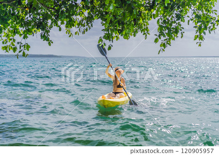 Woman kayaking on Bacalar Lake in Mexico. Adventure tourism in Quintana Roo, outdoor exploration, and water activities concept 120905957
