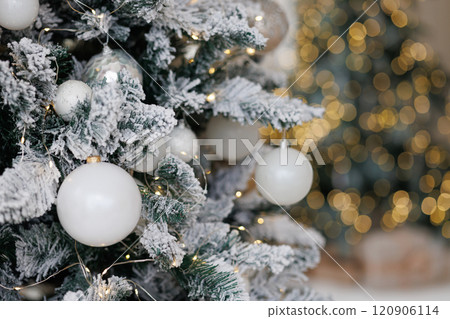 Close-up of a Christmas tree against a background of blurry garland lights. 120906114