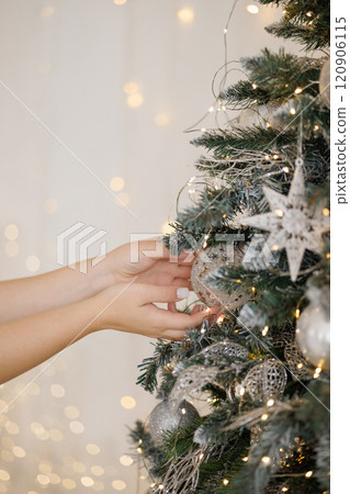 Woman decorating Christmas tree at home, closeup Woman decorating Christmas tree at home, closeup 120906115