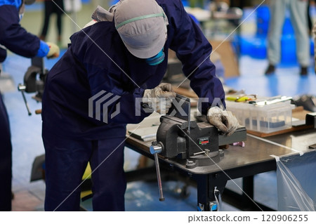 Technical intern trainee filing a file, deburring 120906255