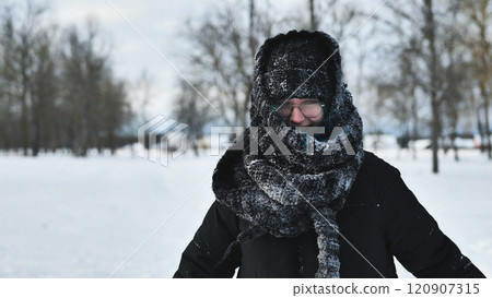 Schoolgirl enjoys a snowy day in the park, wearing a frozen hat and scarf during a winter photoshoot Schoolgirl enjoys a snowy day in the park, wearing a frozen hat and scarf during a winter photoshoot 120907315