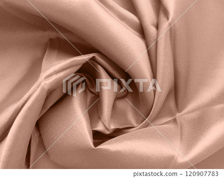 Mocha Mousse - the color of the year 2025. Close-up of beige fabric with soft folds and twisting patterns 120907783