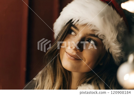 Portrait of cheerful young woman wearing red Christmas hat 120908184