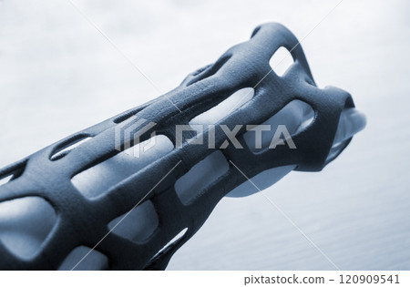Hand splint corset prosthesis printed on 3D printer from molten black plastic powder on hand. Medical orthosis fixator plastic overlay created on 3D printer. New modern medical 3D printing technology, Hand splint corset prosthesis printed on 3D printer from molten black plastic powder on hand. Medical orthosis fixator plastic overlay created on 3D printer. New modern medical 3D printing technology, 120909541