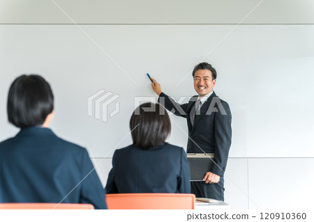 在會議、補習班、研討會、學習會議或簡報會上接受教師、講師、教師或商人的演示的女性 120910360