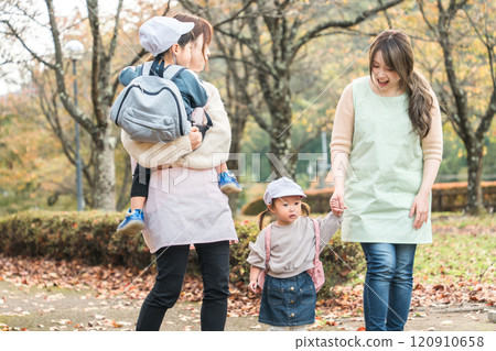 A female nursery teacher and children walking in an autumn park (nursery school, kindergarten, nursery teacher, walk, field trip) 120910658