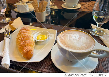 A cafe breakfast decorated with latte art and croissants 120910997