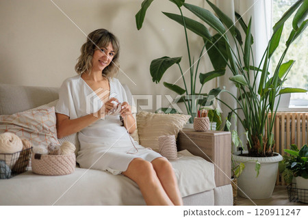 Young beautiful woman crochet handmade use hook knitting needles and wool yarn relaxing on couch Young beautiful woman crochet handmade use hook knitting needles and wool yarn relaxing on couch 120911247