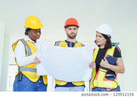 Engineer team discuss and examine about the building plan on blueprint together. Professional engineers working in the construction site. Engineer team discuss and examine about the building plan on blueprint together. Professional engineers working in the construction site. 120912158