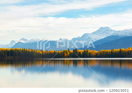 Tranquil lake waters at the mountain foot in autumn forest. Tranquil lake waters at the mountain foot in autumn forest. 120913051