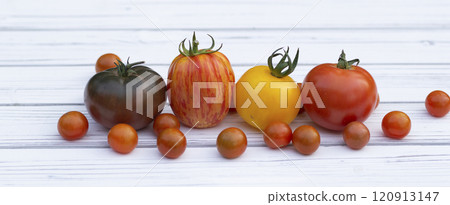 Variety of colorful tomatoes on the white wooden rustic table. Variety of colorful tomatoes on the white wooden rustic table. 120913147