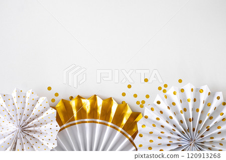 Tissue gold paper fans and honeycombs on the white background. Holiday concept, New Year  120913268