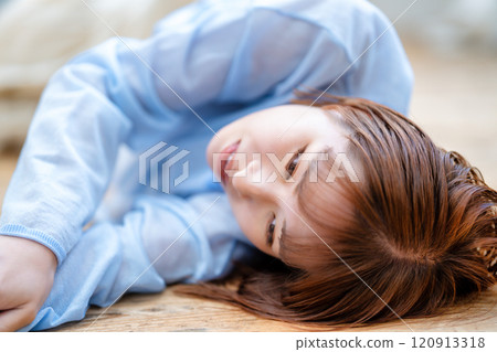 A young woman with a short bob lying on the floor 120913318
