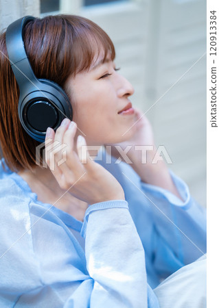 短鮑伯的年輕女子用耳機聽音樂 120913384