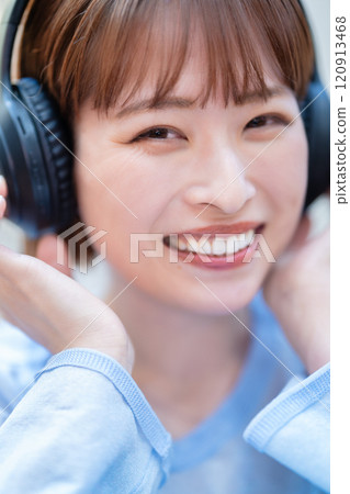 A young woman with a short bob listening to music with headphones A young woman with a short bob listening to music with headphones 120913468